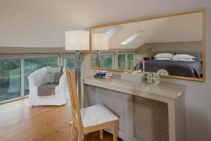 1 dormitorio con cama y escritorio con espejo en Heiton Mill House, en Kelso