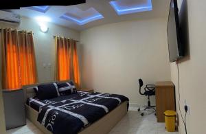 a bedroom with a bed and a flat screen tv at CasaCasa Apartments in Enugu