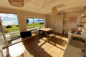 a kitchen with a table and a view of the ocean at Pohara's Beach House in Pohara