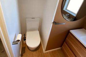 a small bathroom with a toilet and a mirror at Pohara's Beach House in Pohara