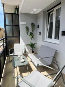 a balcony with chairs and a table and a window at Nuevo piso con terraza en el centro del espolón in Santo Domingo de la Calzada