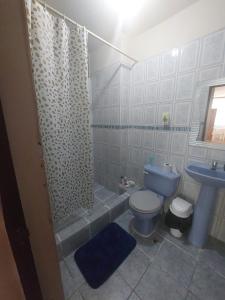 ein Bad mit einer Dusche, einem WC und einem Waschbecken in der Unterkunft Departamentos de la Costa in Machala