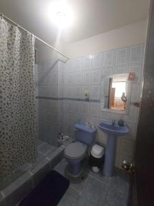 uma casa de banho com um WC azul e um lavatório. em Departamentos de la Costa em Machala