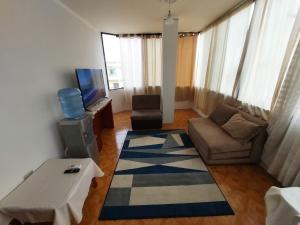 uma sala de estar com um sofá e uma televisão em Departamentos de la Costa em Machala