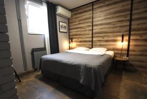 a bedroom with a bed and a wooden wall at Rooms Kaktus in Velika Gorica