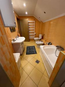 a bathroom with two toilets and a sink and a tub at Apartman Iris in Vogošća