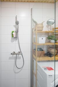 un bagno con doccia e piastrelle bianche di Cozy 1-bed super flat, 20 min to Helsinki/Airport a Vantaa