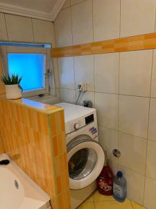 a small bathroom with a washing machine and a window at Apartman Iris in Vogošća