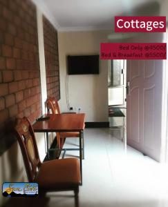 una sala da pranzo con tavolo, sedie e porta di Sunciti Resort Sagana 