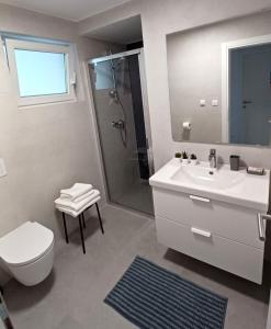 a bathroom with a sink and a toilet and a shower at Apartments Daria in Krk