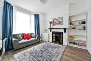 a living room with a couch and a fireplace at Greenwich Holiday Home in London