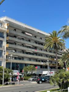 a large building with cars parked in a parking lot at Royal lux promenade des anglais in Nice