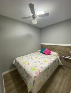 Cama en habitación con ventilador de techo en Apartamento Playa Algaida, en Sitio de Calahonda