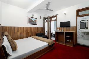 una camera d'albergo con letto e TV di Hotel Kullu Valley a Kulu