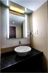 a bathroom with a sink and a large mirror at Hotel Care Holiday Banjara- a Luxury Collection Hotel- An Svm Hotel in Hyderabad
