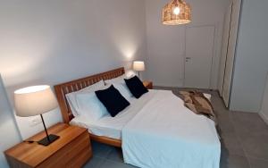 a bedroom with a bed with white sheets and black pillows at Apartments Daria in Krk
