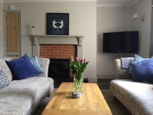 a living room with a vase of flowers on a coffee table at Truck House, Luxury accommodation, pet friendly in Truro