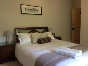 a bedroom with a large white bed with pillows at Truck House, Luxury accommodation, pet friendly in Truro