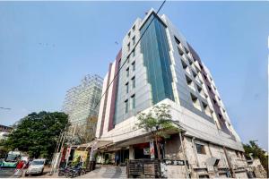 a tall building with glass windows on a city street at Hotel Care Holiday Banjara- a Luxury Collection Hotel- An Svm Hotel in Hyderabad