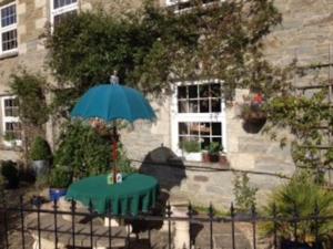 a table with an umbrella in front of a building at Truck House, Luxury accommodation, pet friendly in Truro