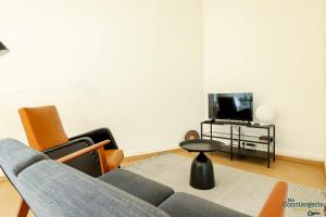 - un salon avec un canapé, des chaises et une télévision dans l'établissement Fac 6 - Vue Garonne - Tram - Parking, à Toulouse