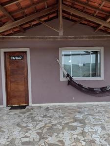 een kamer met een deur, een raam en een touw bij Chalés Recanto das Flores in Bueno Brandão