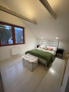 1 dormitorio con cama y reposapiés en DOMKI w LESIE NAD RZEKĄ en Międzybrodzie Bialskie