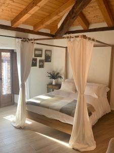 Un dormitorio con una cama con cortinas. en HOTEL RURAL SANTUI, en Horcajuelo de la Sierra