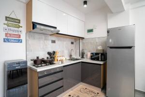 a kitchen with white cabinets and a stainless steel refrigerator at High Rise Haven: Panoramic Views in Nairobi