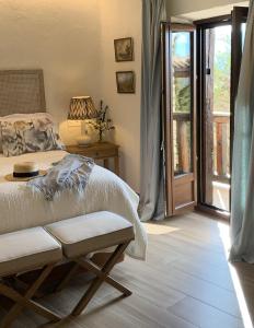 um quarto com uma cama e uma porta de vidro deslizante em HOTEL RURAL SANTUI em Horcajuelo de la Sierra