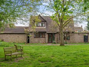 a park bench in front of a brick house at 3 Bed in West Mersea 94316 in West Mersea