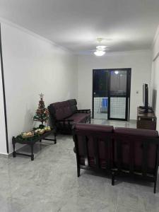 a living room with a couch and a christmas tree at Apartamento com vista do mar in Praia Grande