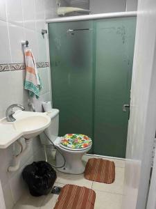 a bathroom with a toilet and a shower and a sink at Apartamento com vista do mar in Praia Grande