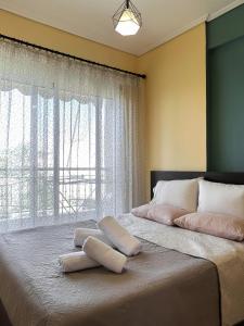 a large bed with two pillows on it with a window at FK Maison in Agrinio
