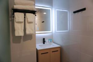 a bathroom with a sink and a window and towels at Leon Hotel LES in New York