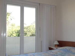 um quarto com uma cama e uma grande janela em Appartement Cavalaire-sur-Mer, 3 pièces, 4 personnes - FR-1-100-187 em Cavalaire-sur-Mer