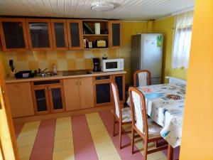 a kitchen with a table and a refrigerator at BO-ZSO Apartman in Vonyarcvashegy