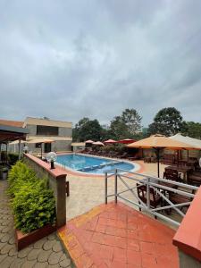 een groot zwembad met tafels en parasols bij The L Suite Apartment in Nairobi +10 foto's