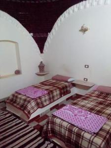 2 Betten in einem weißen Zimmer mit 2 Betten sidx sidx sidx sidx in der Unterkunft oasis panorama in Mandīshah