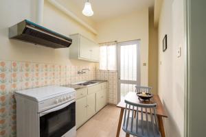 uma pequena cozinha com um fogão e um lavatório em Sainis Rooms em Selianitika