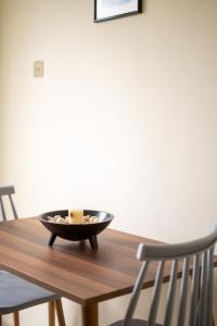 uma tigela em cima de uma mesa de madeira com duas cadeiras em Sainis Rooms em Selianitika