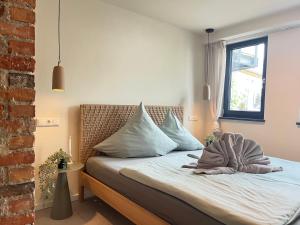 ein Bett mit einer Decke auf dem Zimmer in der Unterkunft Haus Shiralee - Das Ferienhaus Warnemünde in Warnemünde