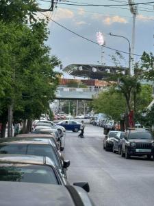 una calle con coches aparcados y un tren en un puente en Thess Comfort House A, en Tesalónica