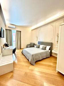 1 dormitorio con cama, escritorio y silla en Sea Pearl Luxury Rooms, en La Spezia