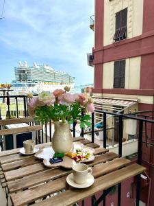 a table with a vase of flowers and a cruise ship at Sea Pearl Luxury Rooms in La Spezia