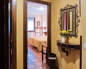 a room with a bed and a mirror on the wall at As Tapias Apartamentos in Tapia de Casariego
