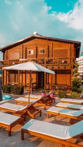 a building with a bunch of tables and an umbrella at Prego Lux in Ulcinj