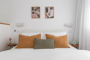 Una cama blanca con almohadas marrones en un dormitorio en Urban Loft, en Oporto