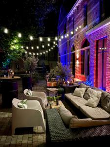 a patio with couches and lights on a building at De Wilden Ezel in Mol