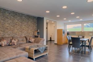 a living room with a couch and a table at Moderne-barrierefreie-Ferienwohnung in Buchenberg